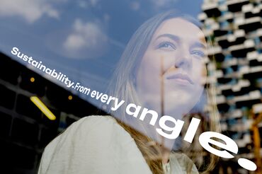 Jeune femme regardant par la fenêtre avec des reflets de la ville.